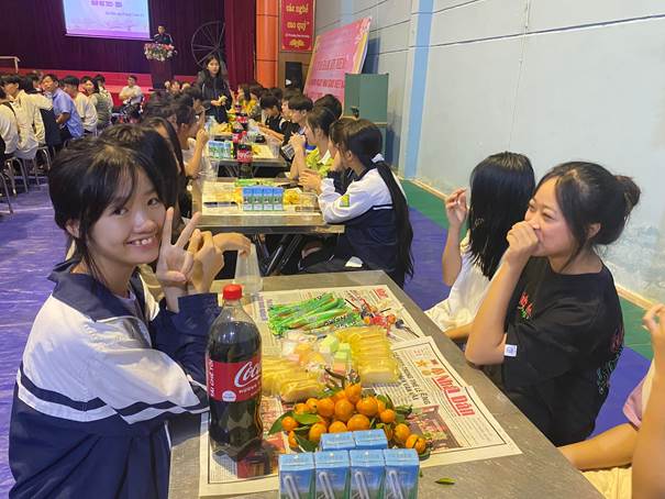 Description: A group of people sitting at tablesDescription automatically generated